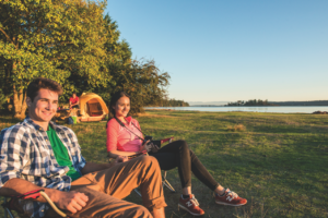 Man and a women sitting by a body of water